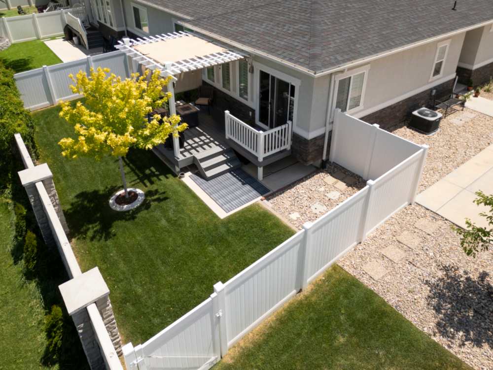 White vinyl fencing with beautiful backyard landscape