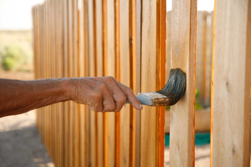 Senior man staining wooden fence in Hillsboro, OR