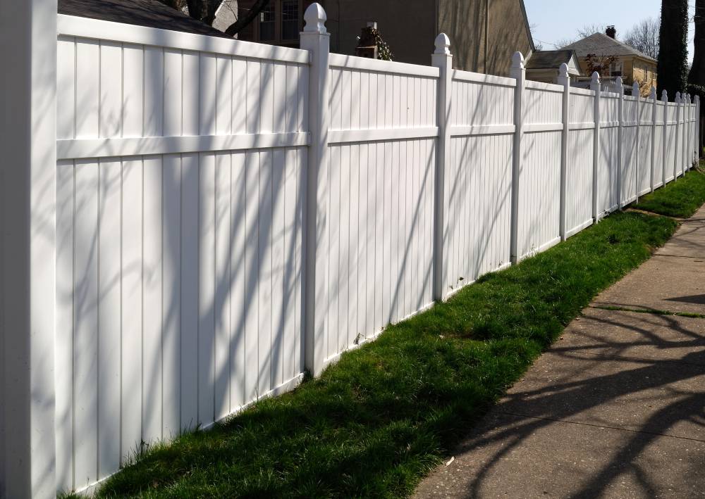 Newly installed shaded white vinyl fence